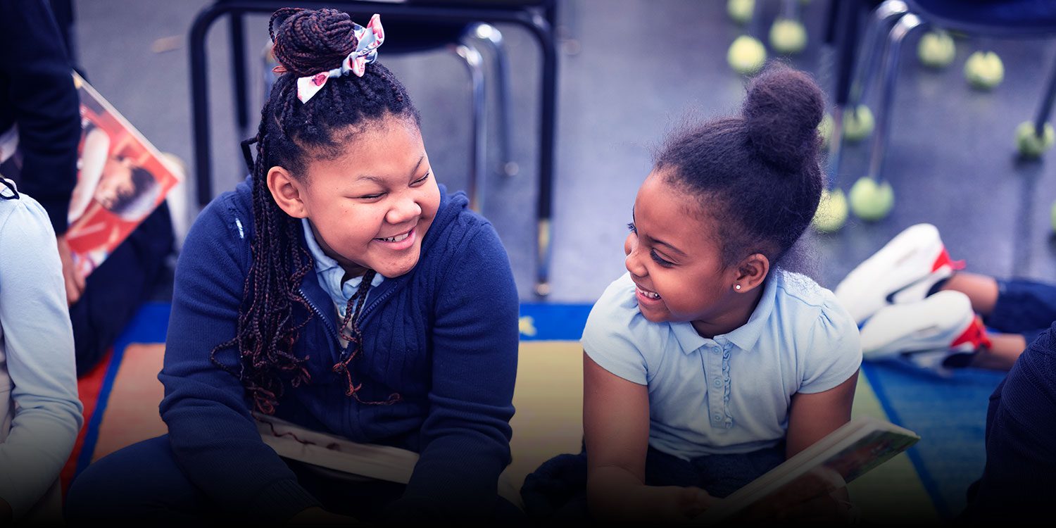 Smiling students in a classroom.